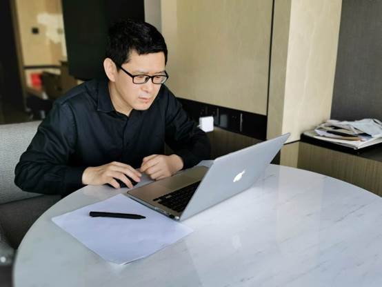 A person sitting at a table using a computerDescription automatically generated with medium confidence